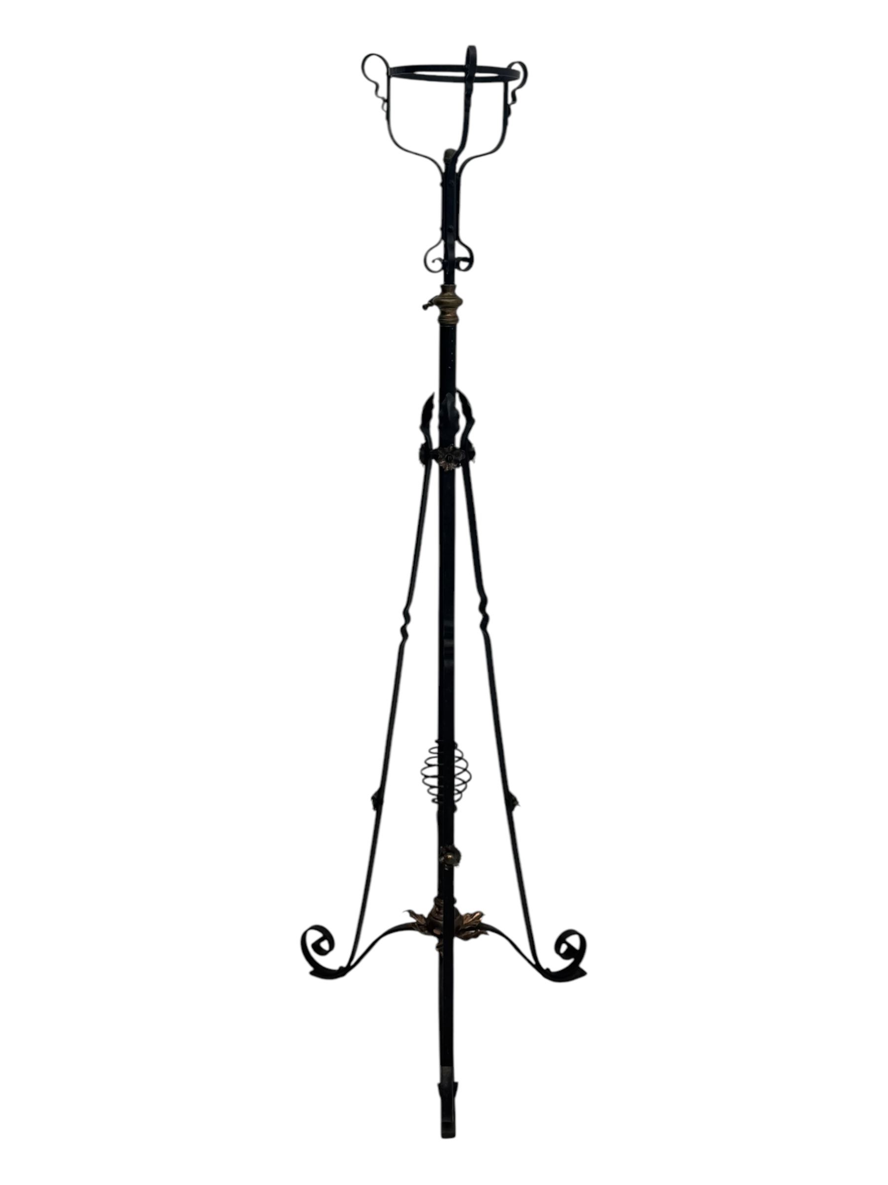 Late 19th century wrought iron and brass pulpit lamp, featuring an adjustable stem with a spiral twist detail, brass foliate mounts, and a tripod base with scrolled feet and decorative floral accents