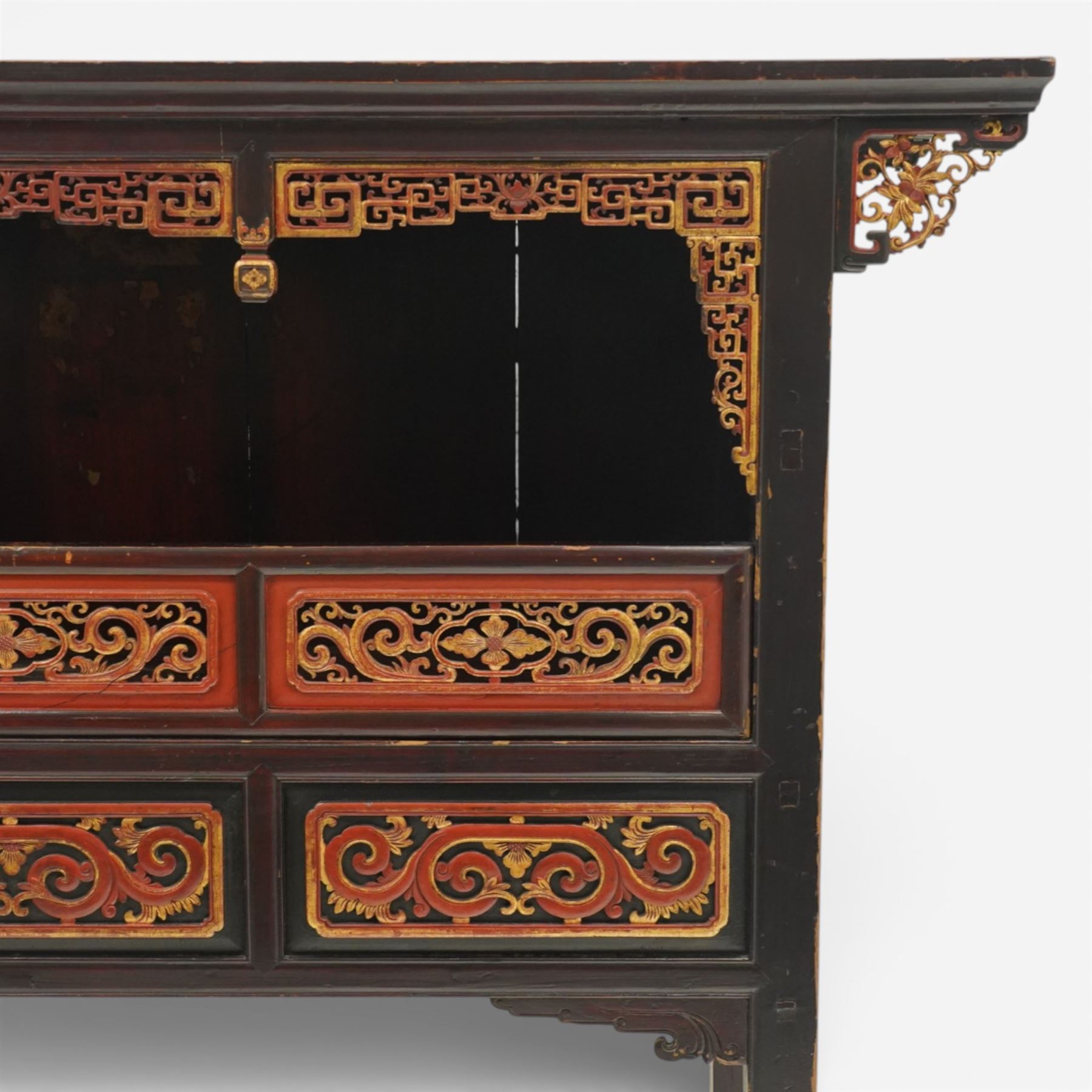 Chinese black lacquer Buddha cabinet, moulded top over open display recess framed by pierced geometric fretwork and corner spandrels, the base fitted with an arrangement of five drawers with carved and gilt scrollwork panels, on square supports with shaped apron brackets