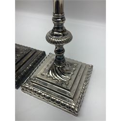 Pair of silver plated Victorian style candlesticks, each of knopped and part fluted form, upon square stepped base, with conforming sconces, together with a smaller pair of silver plated candlesticks, each of knopped and part fluted form, upon lobed foot, a silver plated five piece cruet set, in fitted case and three pieces of mother of pearl flatware, tallest H28.5cm