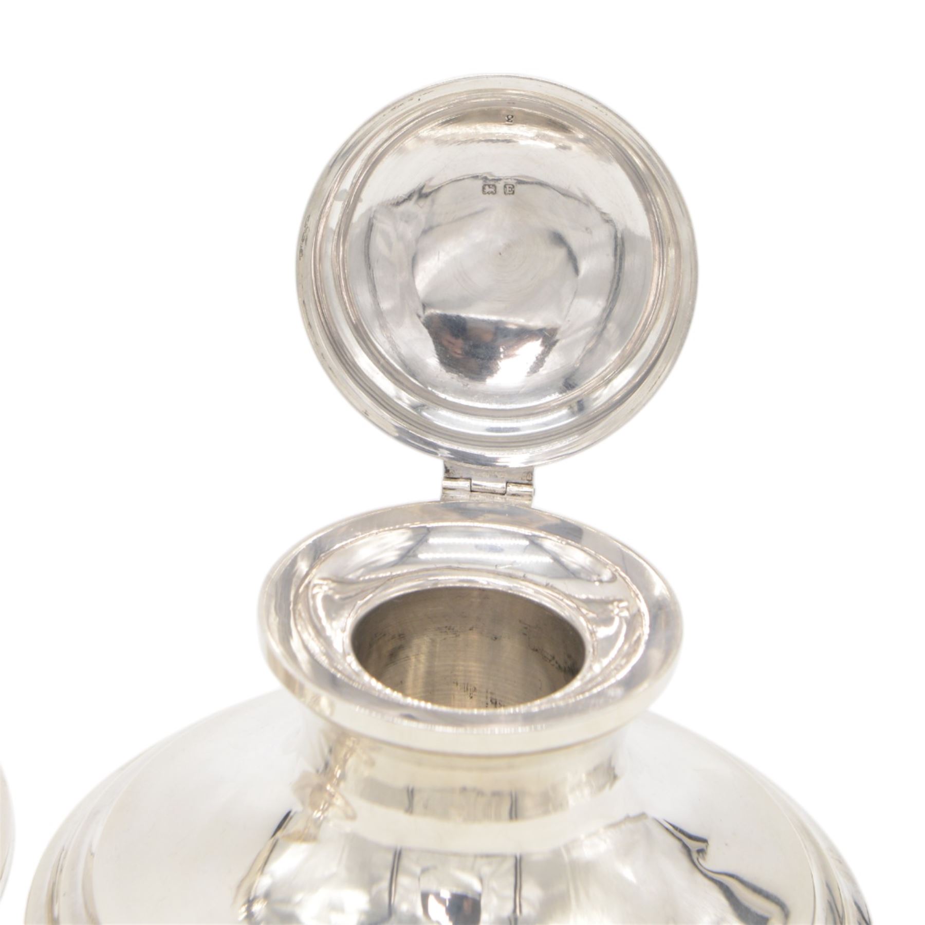 Two early 20th century silver mounted capstan inkwells, both of typical form, the first example hallmarked Wilmot Manufacturing Co, Birmingham 1918, the second example hallmarked Spooner Clowes & Co, Birmingham 1908, largest D15cm, H9.5cm