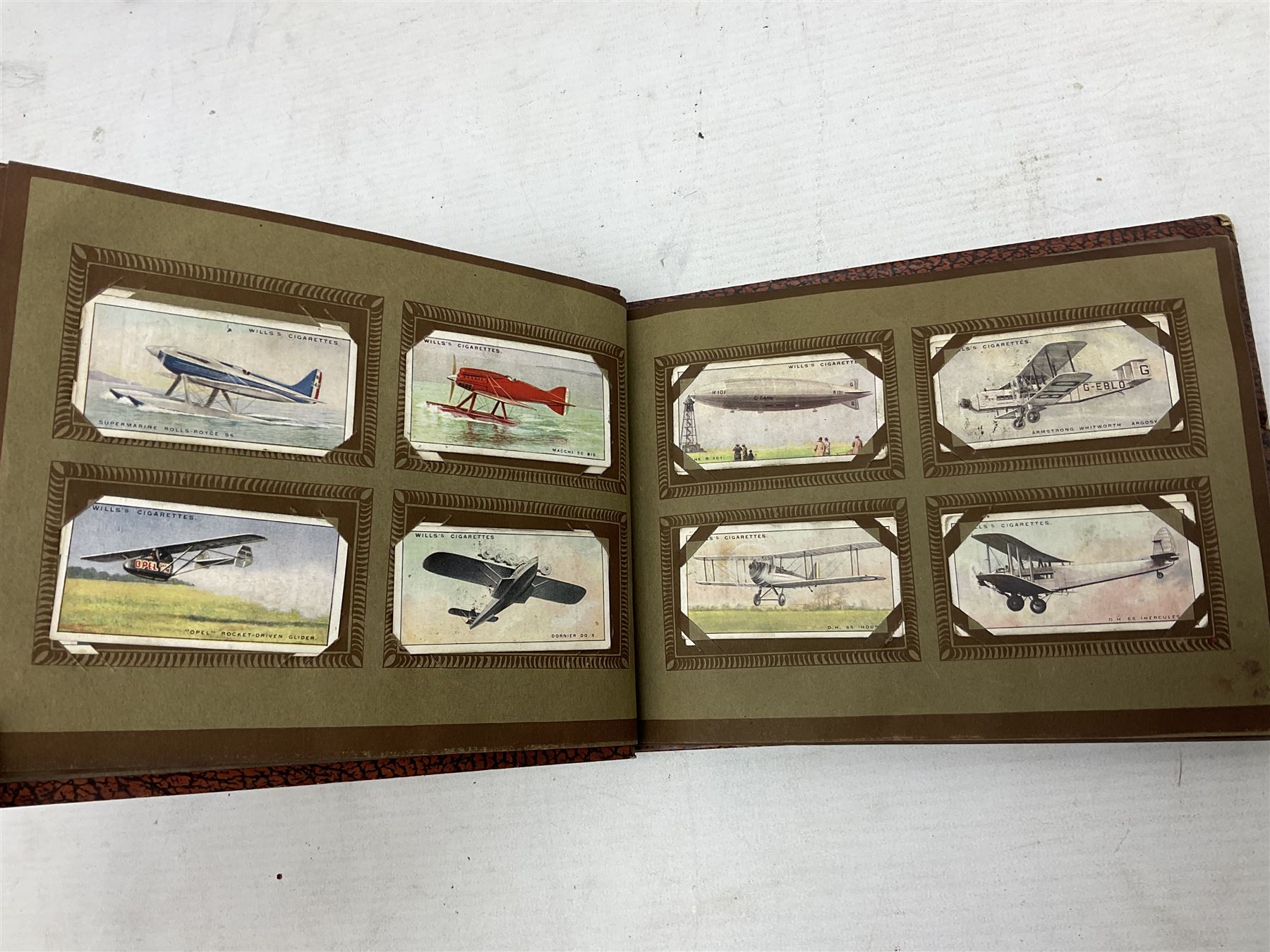 Three albums of cigarette cards including Wills Recruiting Posters, Military Motors and Allied Army Leaders, cricketers etc; another album containing a large quantity of laid-in cigarette cards; and an album of thirty-seven postcards of dogs by Mac (5)