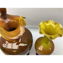 Linthorpe pottery vase with crimped rim and ovoid body, Linthorpe jug with high loop handle and crimped spout, a pair of candlesticks with a green, brown glaze and other similar pottery 