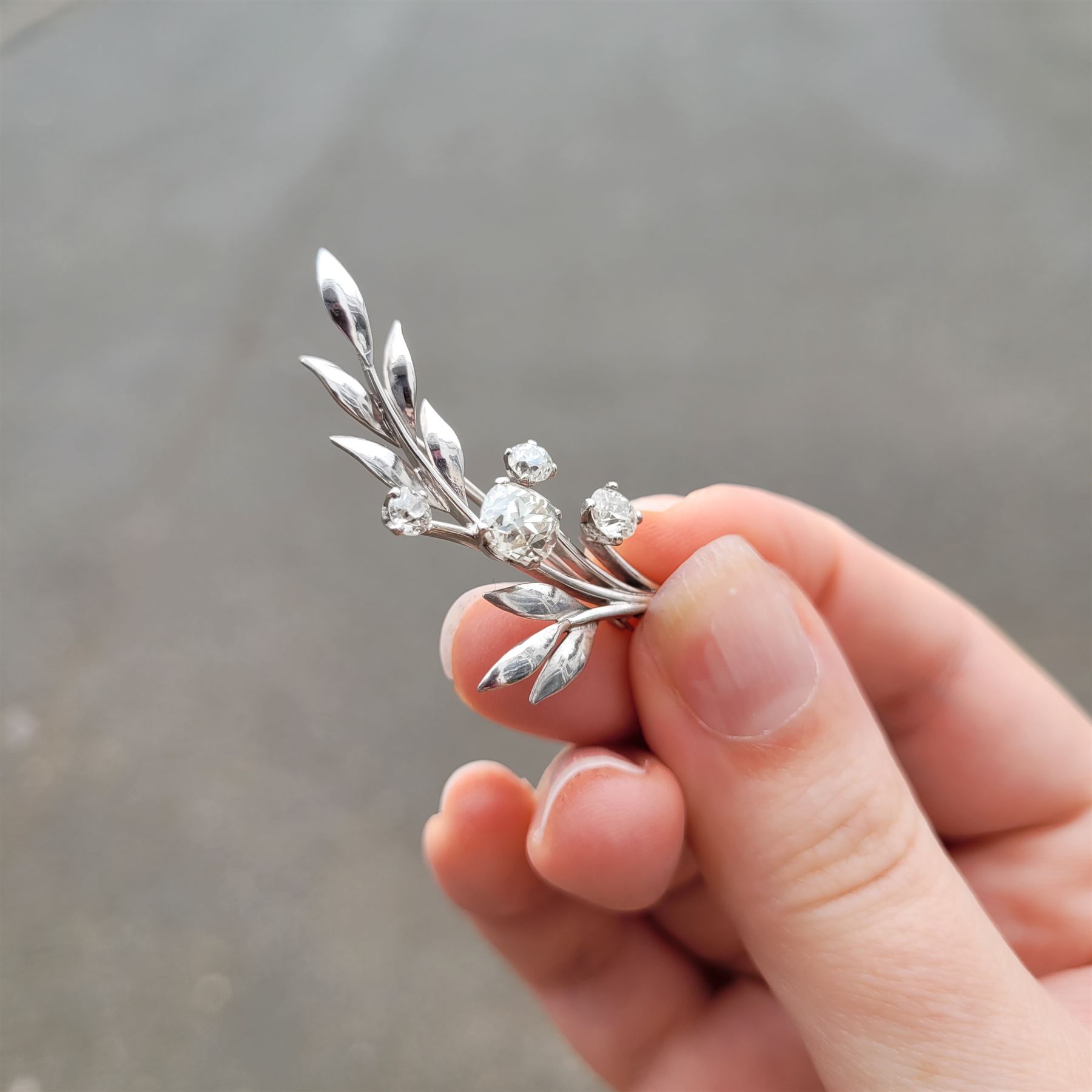 18ct white gold diamond flower brooch, set with a principal old cut diamond of approx 1.00 carat, surrounded by three further old cut diamonds, total diamond weight approx 1.75 carat