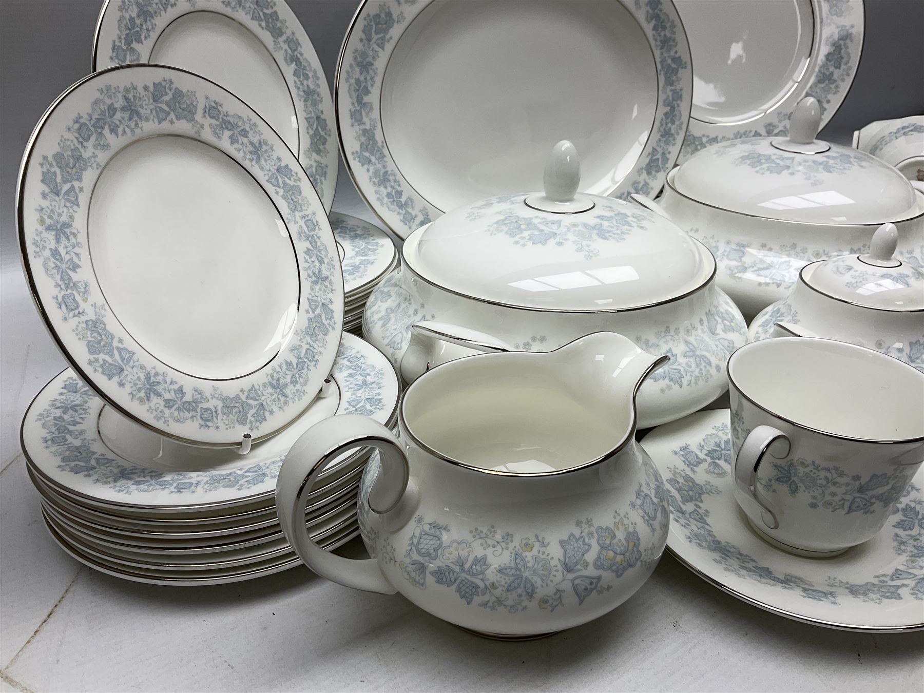 Royal Doulton tea and dinner wares in the Meadow Mist pattern, no H5007, comprising seven dinner plates, eight side plates, two lidded tureens, two jugs, lidded sucrier, oval serving dish, six teacups, seven saucers, seven tea plates and large saucer
