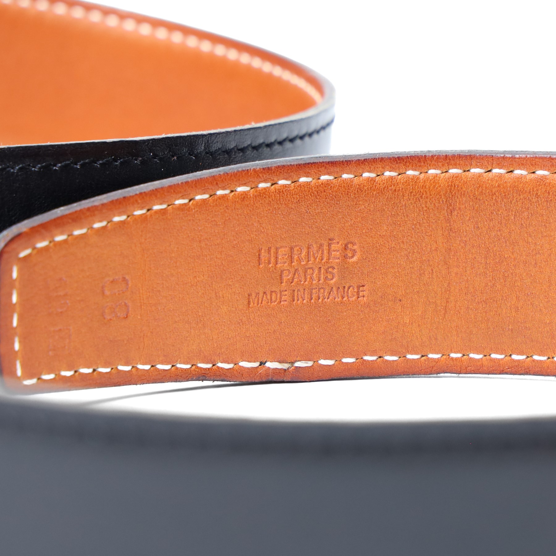 Hermès - reversible black and tan leather belt, with large gilt-metal circular openwork H monogram buckle, size 80, with buckle dust bag and belt dust bag