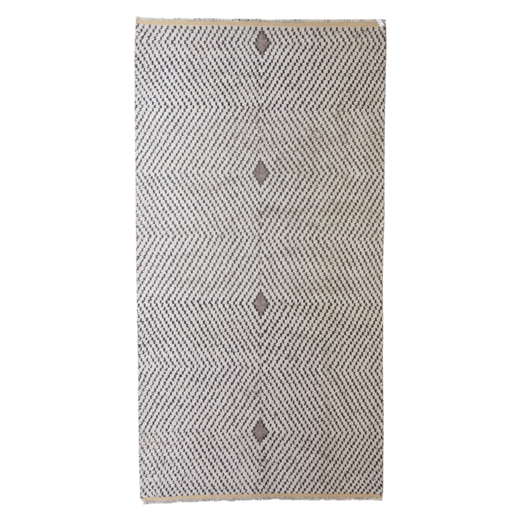 Contemporary Beni Ourain style wool rug, woven with a cream field and dark brown geometric chevron lattice, centred by repeating small diamond medallions, with short fringe ends