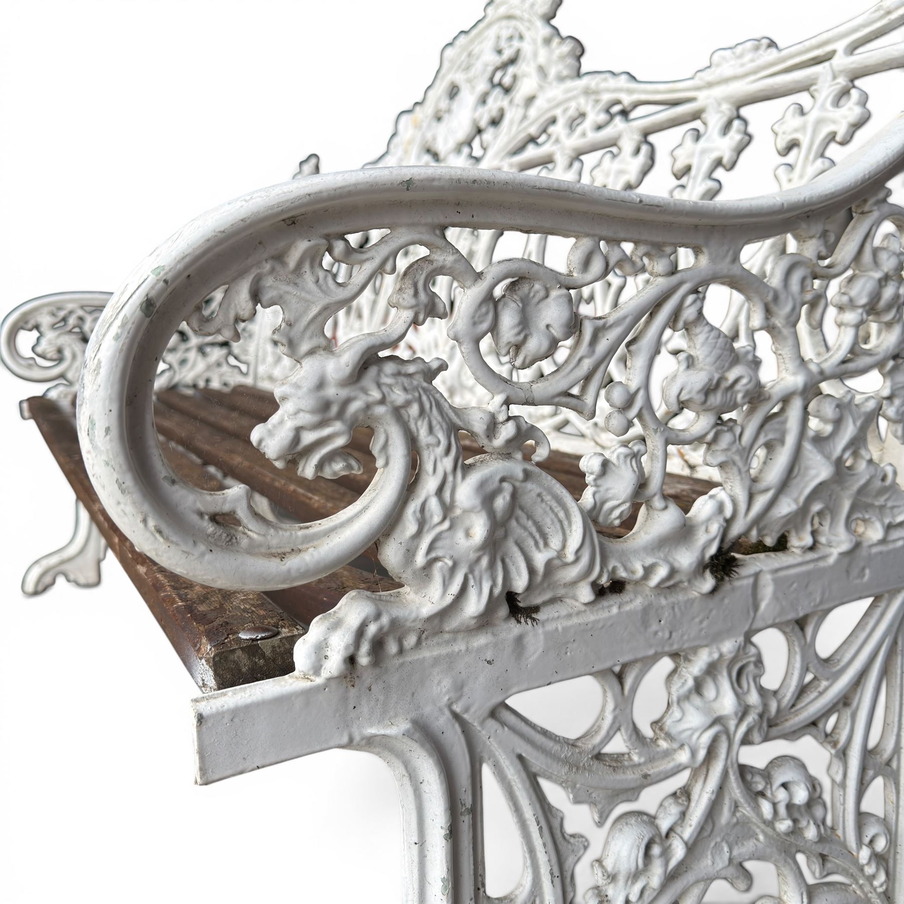 Coalbrookdale Gothic design cast iron and slatted teak garden bench, the ornate pierced back and sides of arched design, with central cartouche shield surrounded by stylised crosses and trefoils with interspersed flowerheads, the scrolled arm terminals with stylised griffon motifs and trailing fruiting vines 