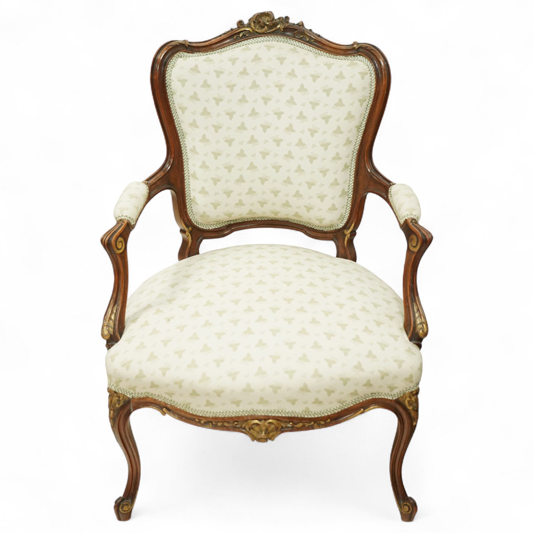 Louis XV design salon suite comprising a pair of walnut and parcel-gilt fauteuil armchairs together with a side chair, the cresting rail surmounted with a carved giltwood floral shell motif with extending foliage, the cartouche shaped backs and sprung seats upholstered in pale blue patterned fabric, over a shaped apron with scallop decoration and foliage carved knees, raised on cabriole supports