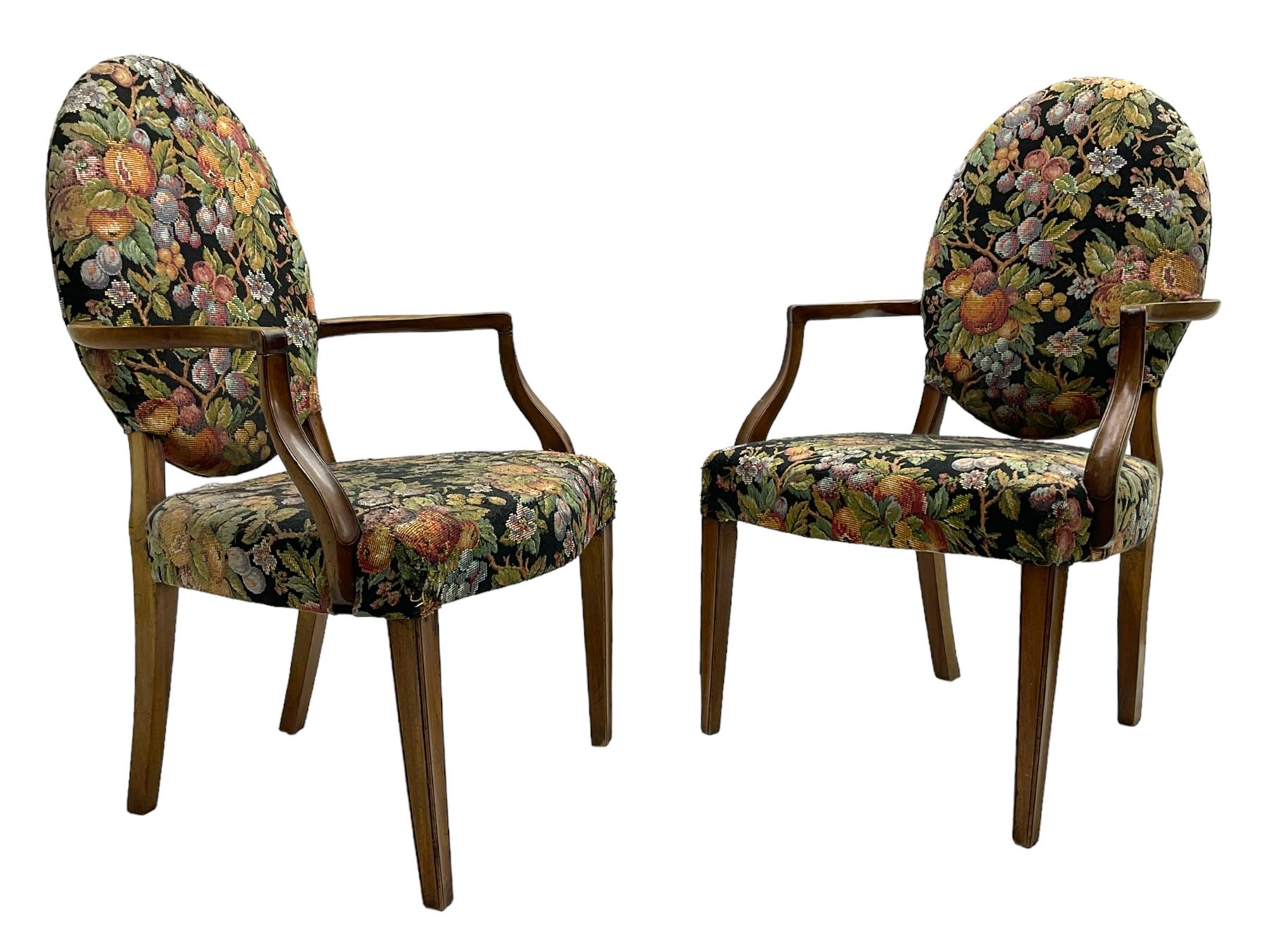 Pair of George III mahogany framed open armchairs, oval back and serpentine seat upholstered in fruit and foliage patterned fabric, shaped and moulded arms and arm supports, on square tapering moulded front supports 
