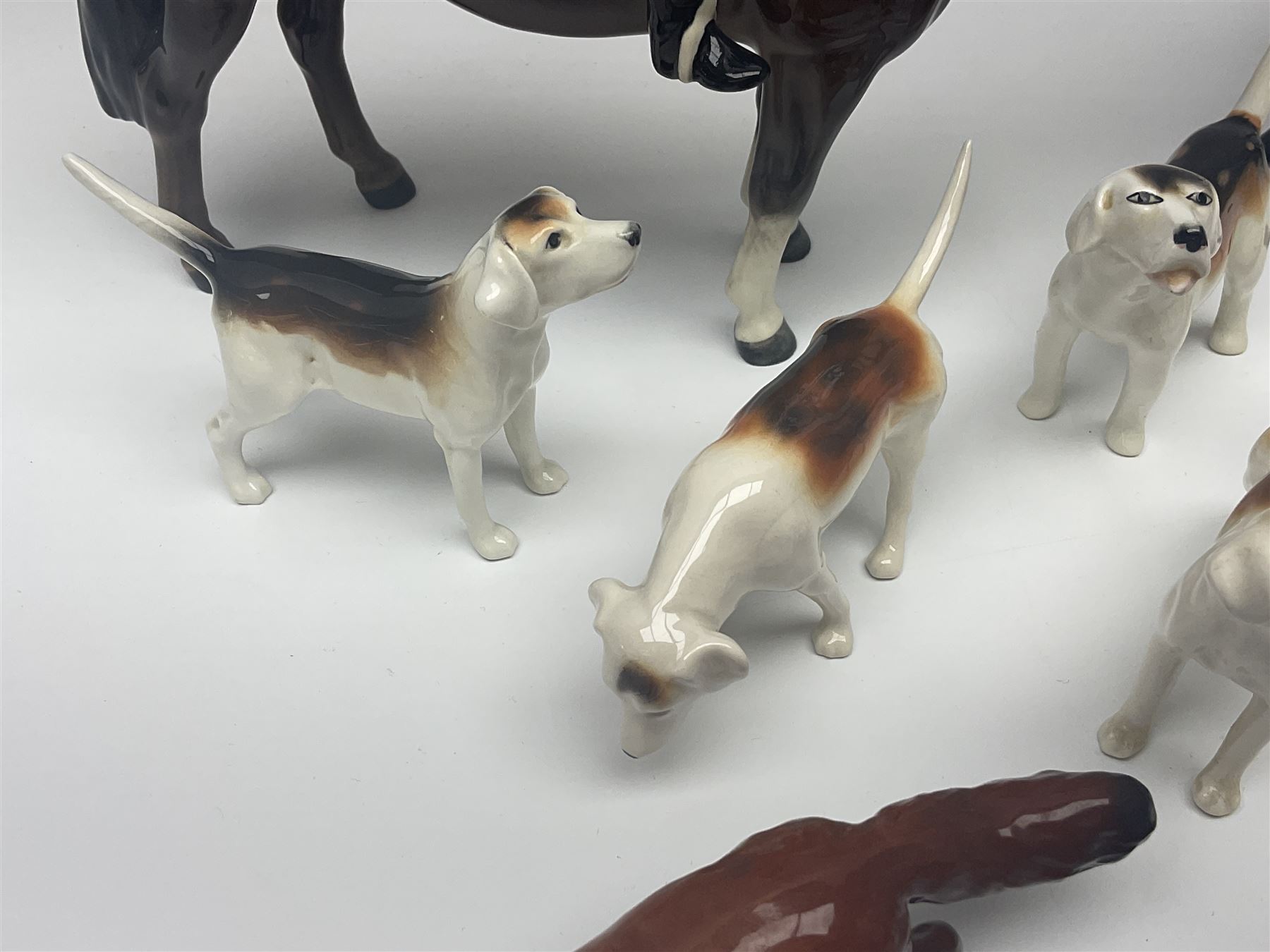 Beswick hunting group, comprising huntswoman on grey horse no 1730, huntsman on brown horse no 1501, fox figure no 1440 and eight fox hounds, all with printed marks beneath (11)