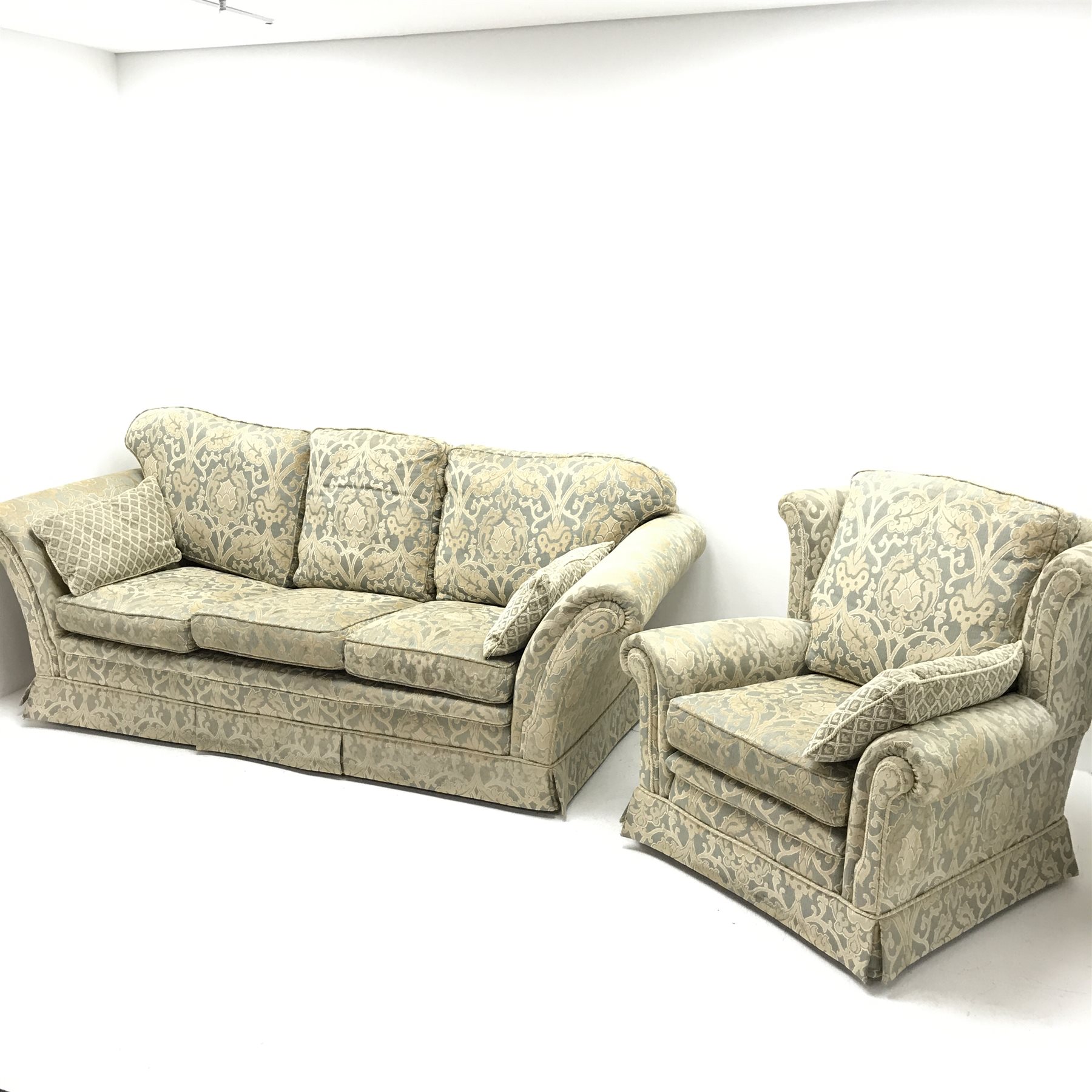 Three seat sofa upholstered in a floral patterned gold and teal fabric