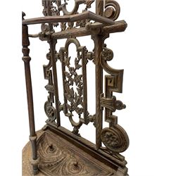 19th century cast iron hallway hat and coat stand, the arched frame decorated with overlapping foliage, central oval mirror surrounded by trailing oak leaves and acorns, with extending umbrella and stick strand, the curved plinth base decorated with acanthus leaves, with impressed and mounted R.d. lozenges