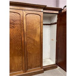 19th century figured mahogany quadruple breakfront press wardrobe, projecting cornice with banded frieze over arch panelled doors, the interior fitted with three sliding trays over two short and three long graduating drawers with recessed brass handles, flanked by two hanging cupboards with hooks