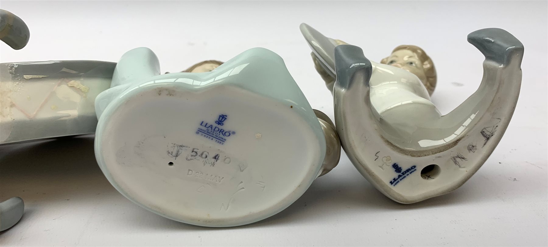  A group of Lladro and Nao figurines, comprising a trio modelled as boys playing instruments, boy with dog, boy with football, girl with puppy and kitten and a goose, (two a/f), all with printed mark beneath.   