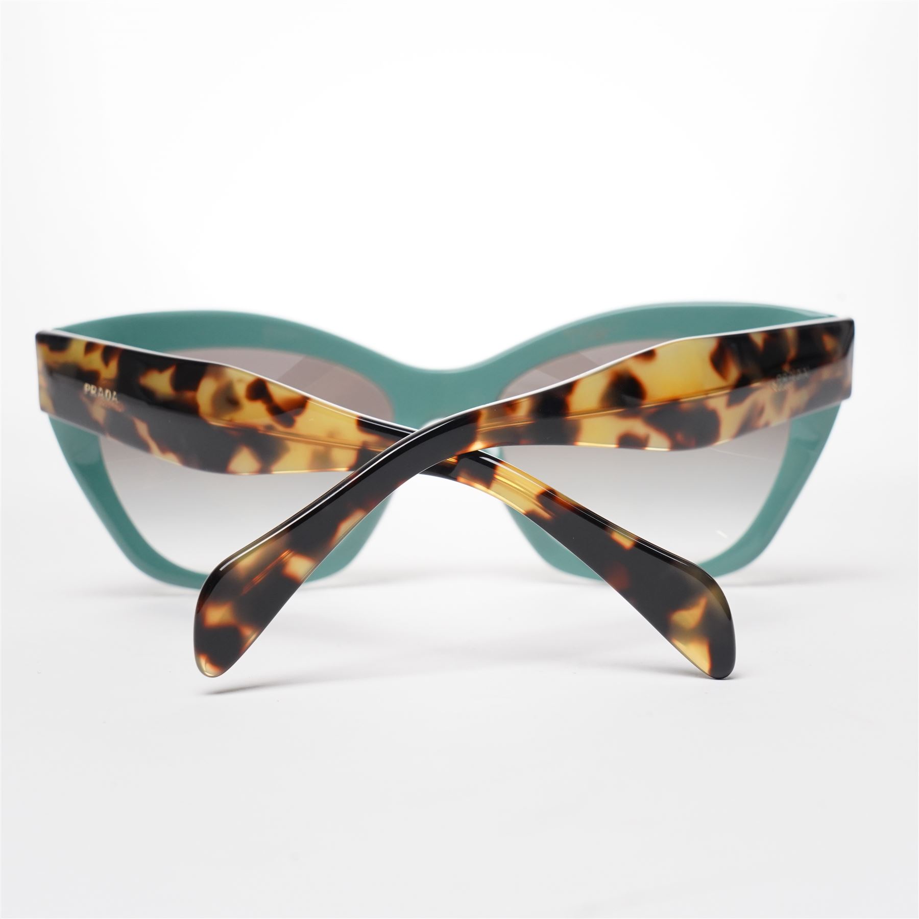 Prada - pair of cat-eye sunglasses, with green acetate frames and graduated tinted lenses, the arms in tortoiseshell finish with gold-tone ‘Prada’ branding, unused with original hard case and box