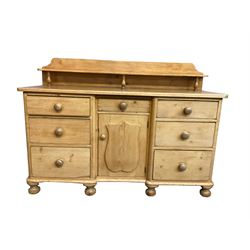 Victorian pine breakfront sideboard or dresser, raised back with shelf, fitted with central drawer and cupboard flanked by six graduating drawers, raised on bun feet