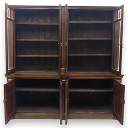 Late 19th century walnut library bookcase, fitted with four display doors with astragal bevelled panes, raised upon a four cupboard base with fielded panel doors