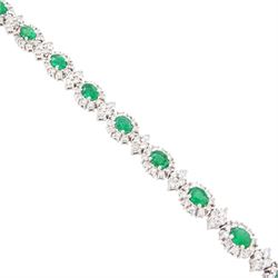 18ct white gold emerald and diamond bracelet, fifteen oval cut emeralds, each surrounded by ten round brilliant cut diamonds and spaced by a further four diamonds, stamped, total emerald weight approx 3.30 carat, total diamond weight approx 2.10 carat