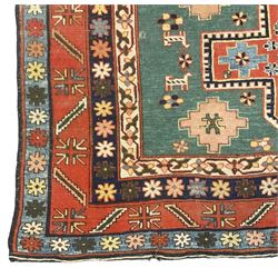 Caucasian turquoise ground rug, two medallions on a field decorated with stylised animal and geometric motifs, the guarded border decorated with further geometric motifs