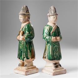 Pair of Chinese terracotta court attendant tomb figures,  probably Ming Dynasty, in Sancai green glaze, upon stepped square bases, H22cm 