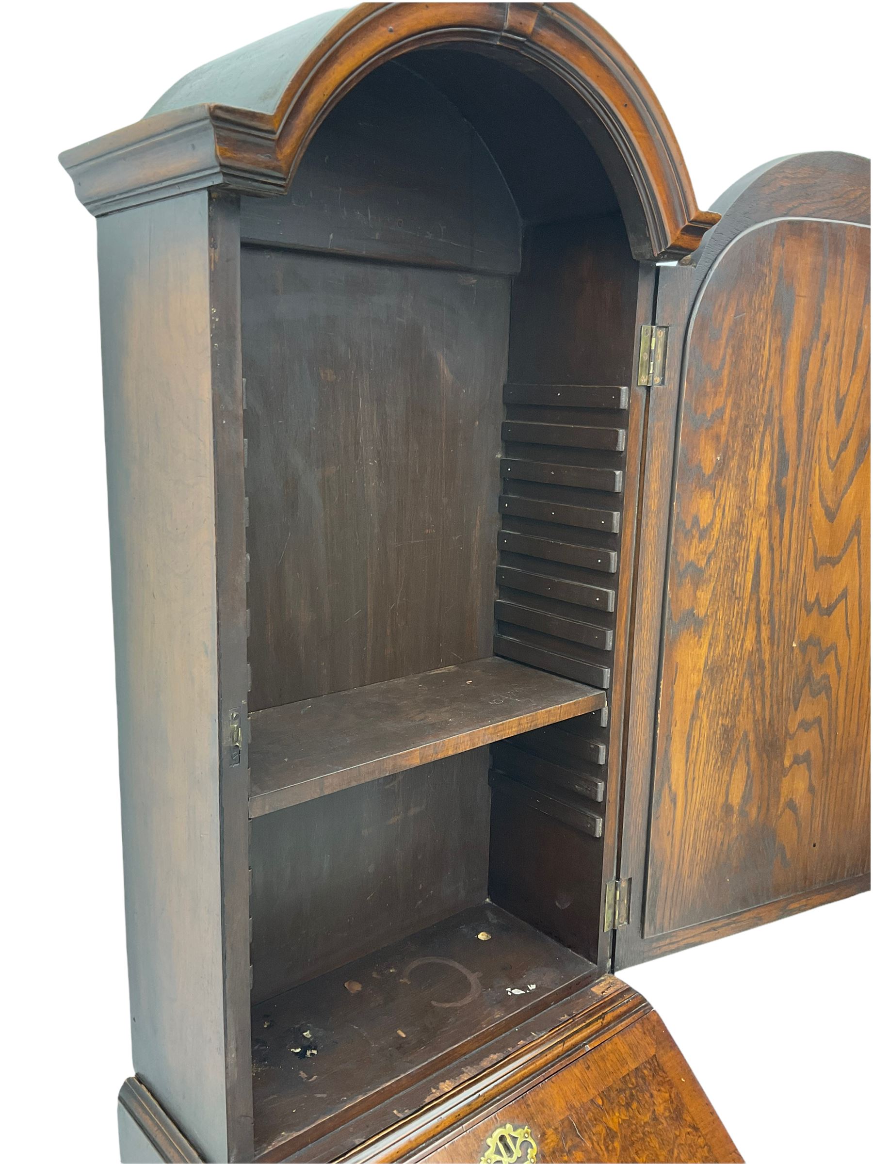 Small early 20th century Queen Anne style bookcase on bureau secretaire, the moulded arched pediment over mirrored door in shaped frame, the bureau fitted with fall front enclosing curved fitted interior, cushion moulded drawer over single drawer, on scroll and shell carved cabriole supports