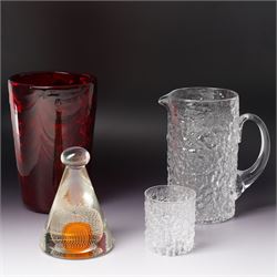 Four Whitefriars glass examples, comprising Ruby Red Wave ribbed vase, designed by Marriot...
