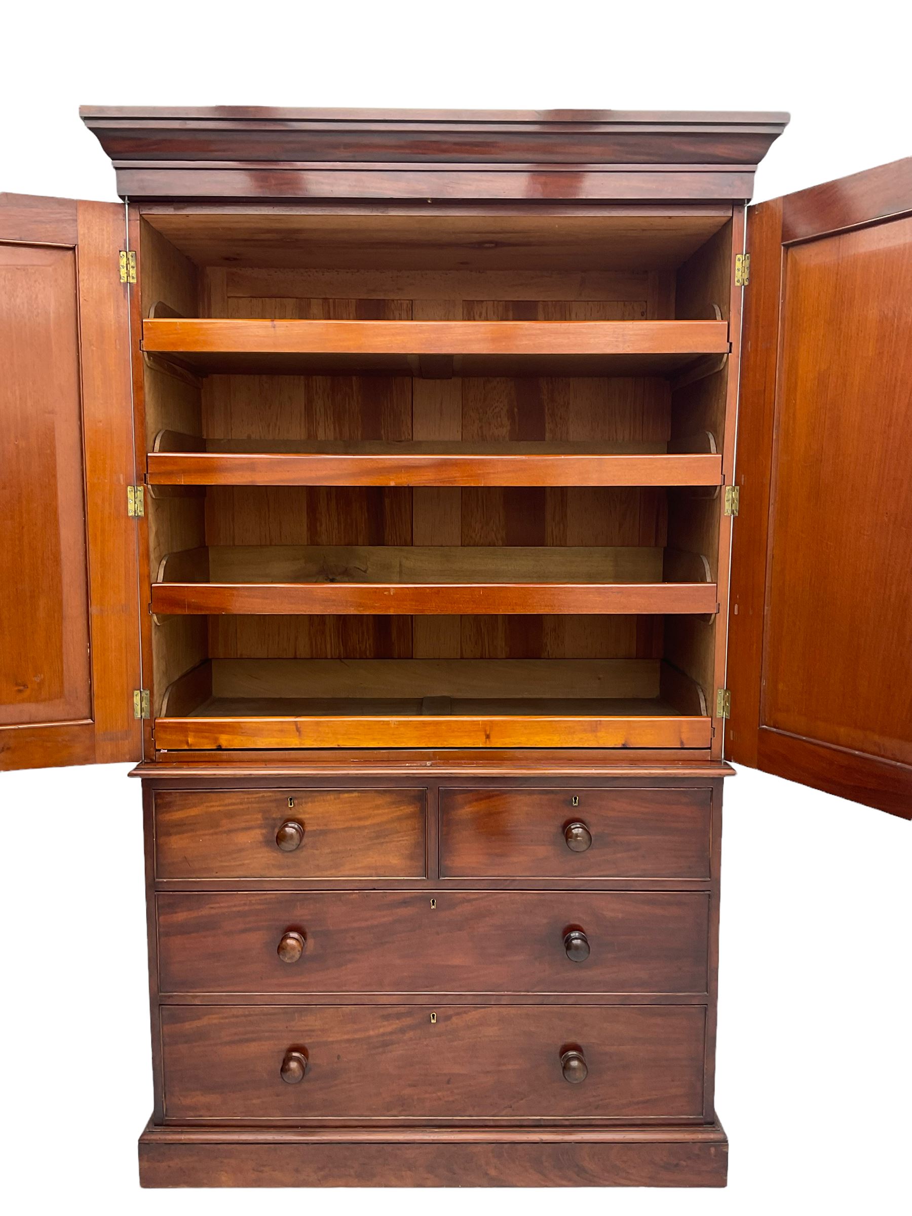 Victorian mahogany linen press, projecting moulded cornice, two doors with arched panels enclosed four linen slides, the lower section fitted with two short and two long drawers, on plinth base