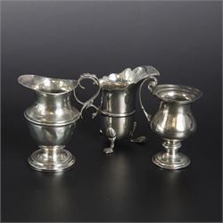 Group of early 20th century silver, comprising sauce boat, with flying scroll handle and upon three pad feet, two small cream jugs and a christening mug, all hallmarked, tallest H10cm