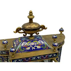 A decorative 20th  century Chinese mantle clock with blue cloisonné decoration and four bevelled glass panels, flat pediment surmounted by four finials and an ornamental central urn, matching full length pillars to the sides with a conforming plinth on raised feet, 8-day striking movement striking the hours and half hours on a coiled gong, dial with Roman numerals, five-minute Arabic’s, minute markers and matching steel trefoil hands, visible pendulum with painted decoration.
