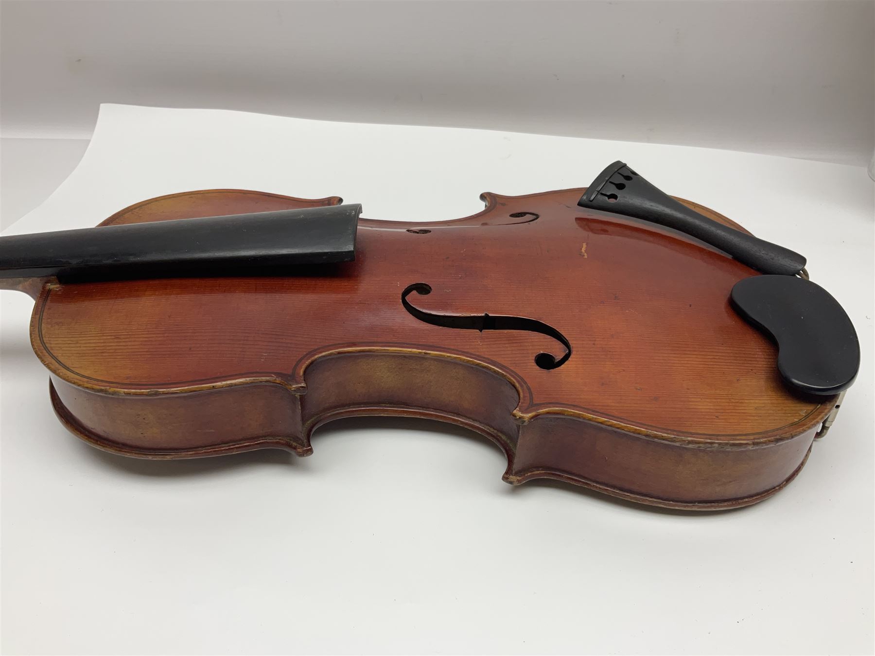Late 19th century French three-quarter size 'Conservatory' violin with 34cm two-piece maple back and ribs and spruce top, the peg box inscribed 'Conservatory Violin Straduari', bears label 'Antonius Stradiuarius Cremonensis Faciebat Anno 1721' L55.5cm overall; in ebonised wooden 'coffin' case; and Saxony violin c1900 with 36cm two-piece maple back and ribs and spruce top; bears label 'Antonius Stradivarius Cremonensis Faciebat Anno 17**' L59cm overall; in carrying case (2)