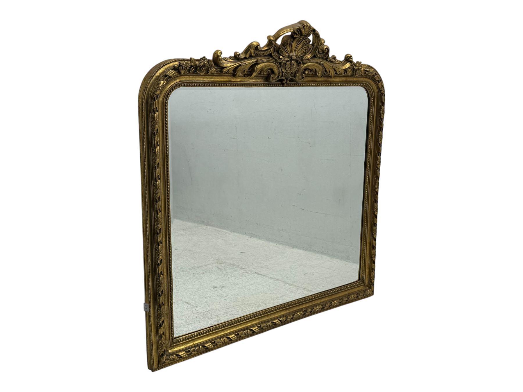 18th century design ornate gilt framed overmantle mirror, bevelled mirror plate within arched frame with pierced pediment featuring foliate and scrollwork designs