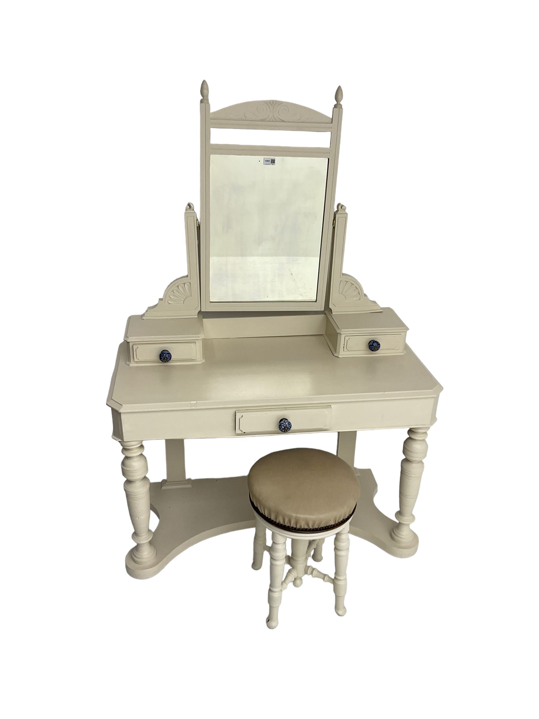 Edwardian cream painted dressing table, fitted with rectangular swing mirror over two trinket drawers with ceramic handles, rectangular top with frieze drawer, raised on turned front supports; with circular stool, leather seat over four turned supports