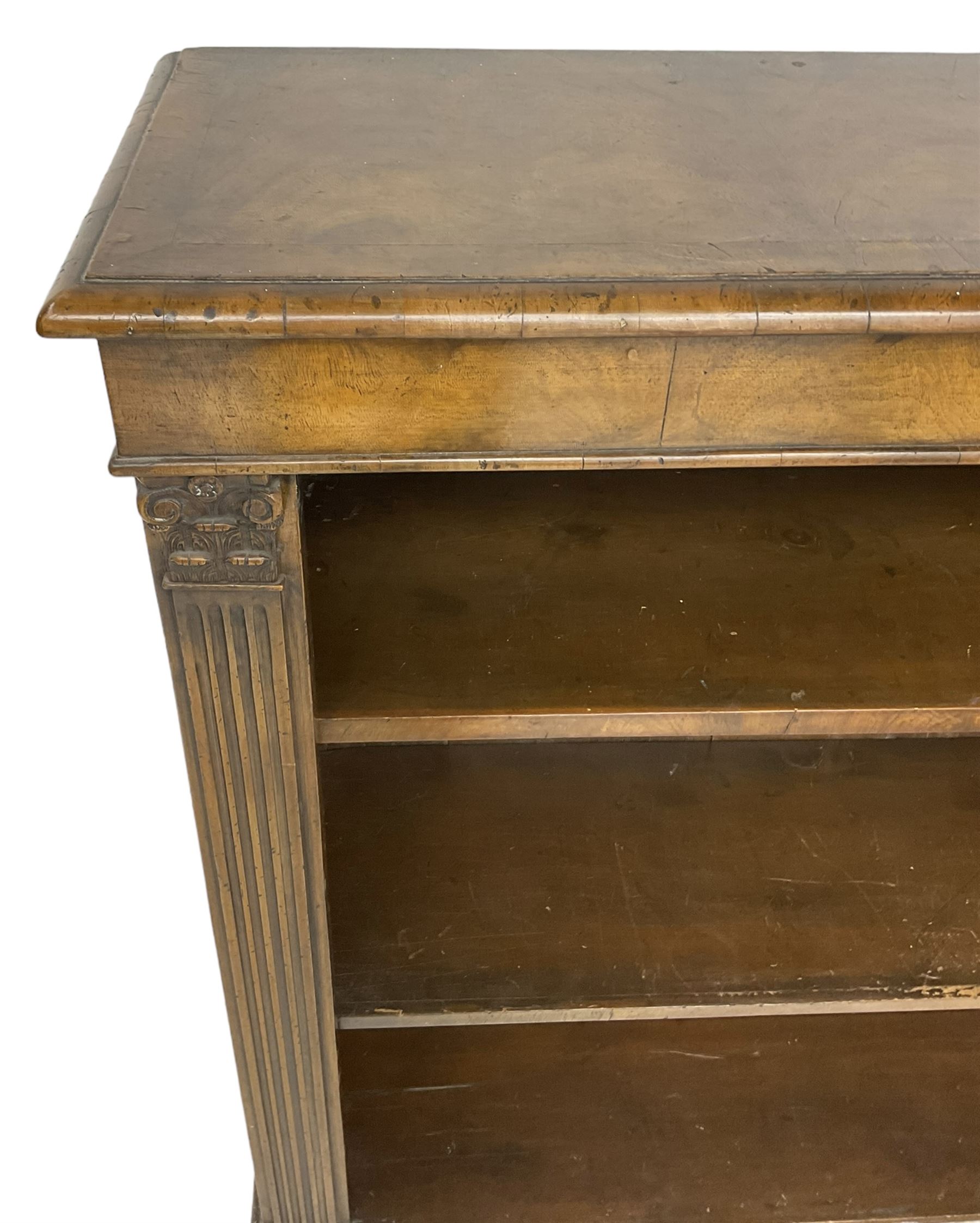 Georgian design walnut open bookcase, fluted uprights with acanthus carved capitals enclosing two adjustable shelves, on bracket feet