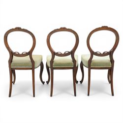 Victorian mahogany dining suite, oval tilt top dining table raised on a quatriform base with paw feet, together with a set of six balloon back dining chairs with green upholstery with cabriole legs 