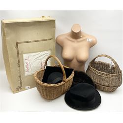 Black homburg hat, graduation hat, two weaved baskets, a mannequin body and wedding dress.  