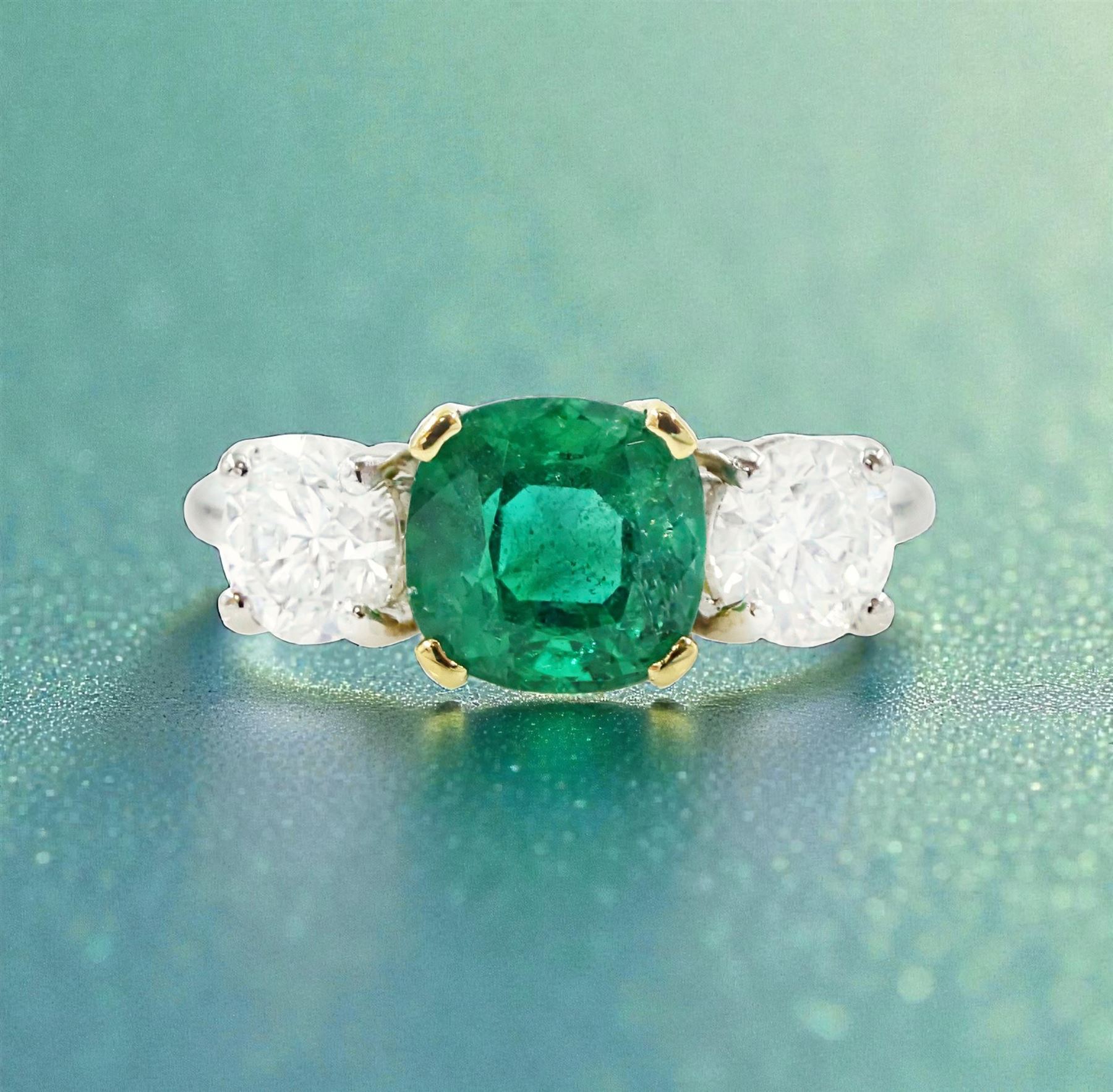 Platinum emerald and diamond three stone ring, single cushion cut emerald of approx  1.85 carat, set with a single round brilliant cut diamond either side, hallmarked, total diamond weight approx 1.20 carat