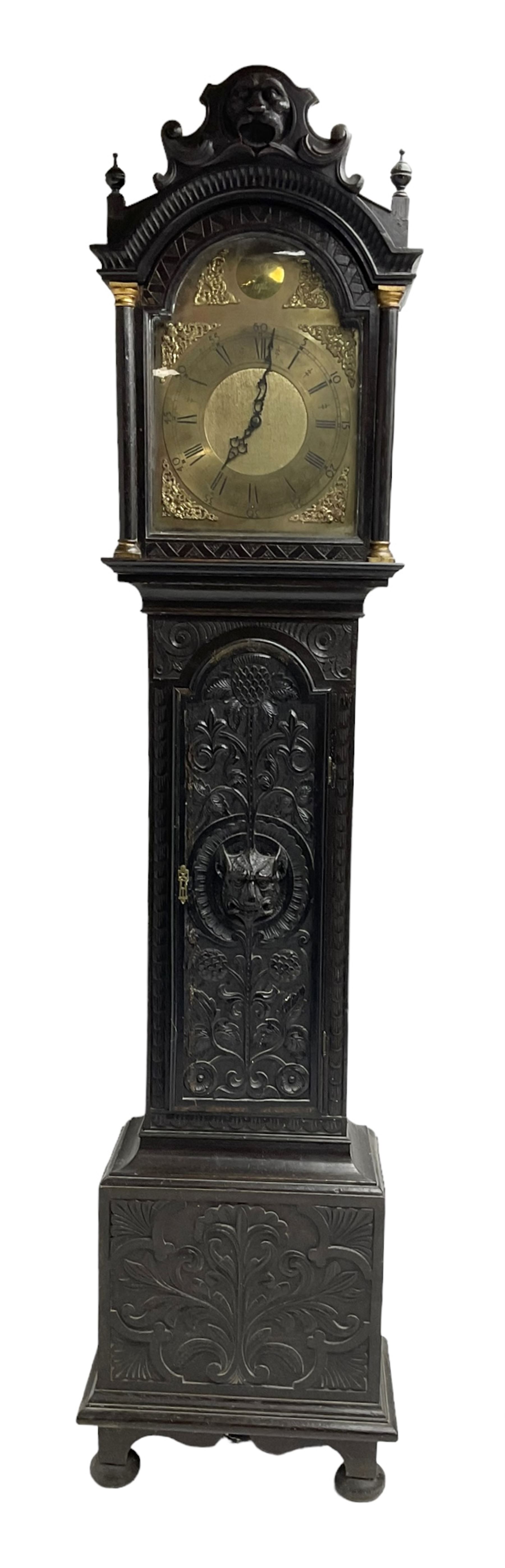 Victorian Jacobean revival oak cased 30 hour longcase clock - with a carved pediment and break arch door beneath, door with attached pilasters and gesso capitals, break arch trunk door with a carved grotesque, conforming carved plinth raised on ball feet, brass dial with spandrels, matted centre and chapter ring, dial pinned to a chain driven countwheel movement, striking the hours on a bell.
With weight and pendulum.