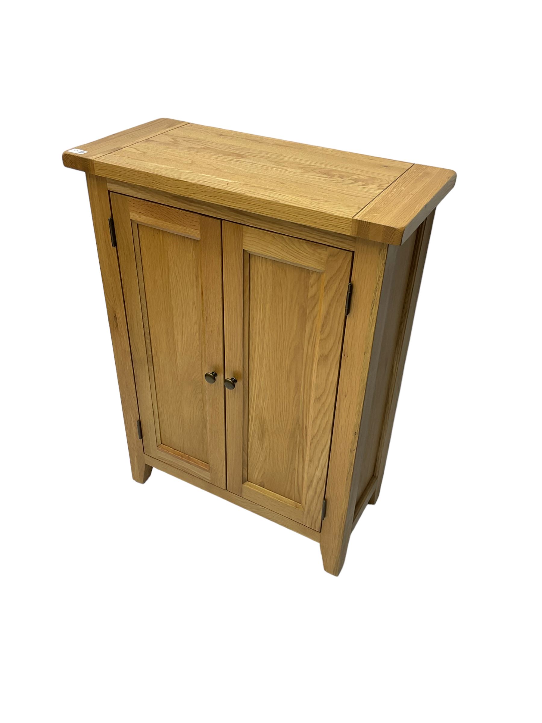 Solid light oak cupboard, fitted with two panelled doors enclosing two shelves, on tapered feet