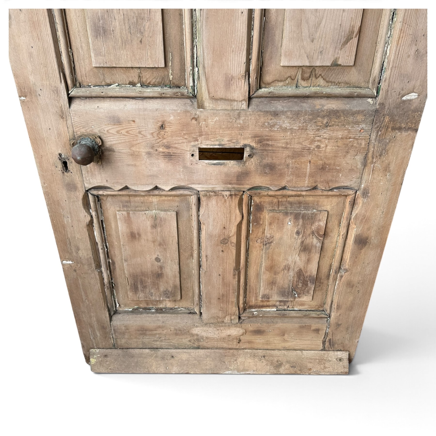 Victorian stripped pine four-panel door, the raised fielded panels within carved foliate and moulded surrounds, with iron lock and fittings and brass knob handle