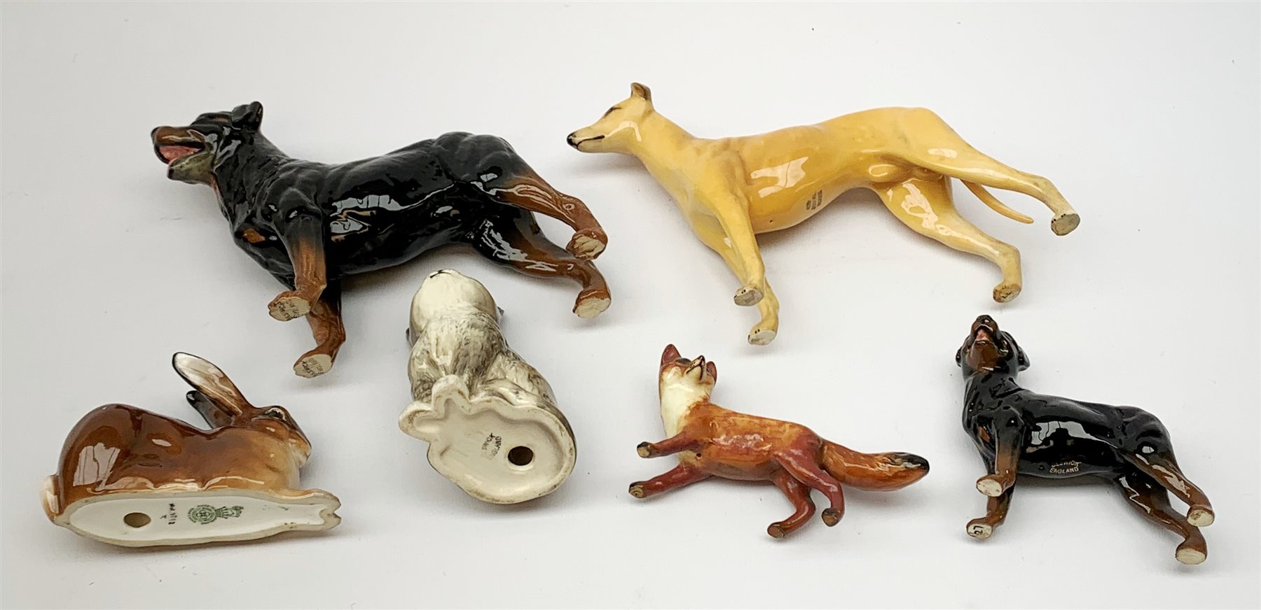 A group of Beswick figures, comprising a Rottweiler, and Rottweiler puppy, Grey Hound marked CH Jovial Roger, grey kitten marked 1886, fox, and a Royal Doulton figure of a Rabbit, HN2592. 