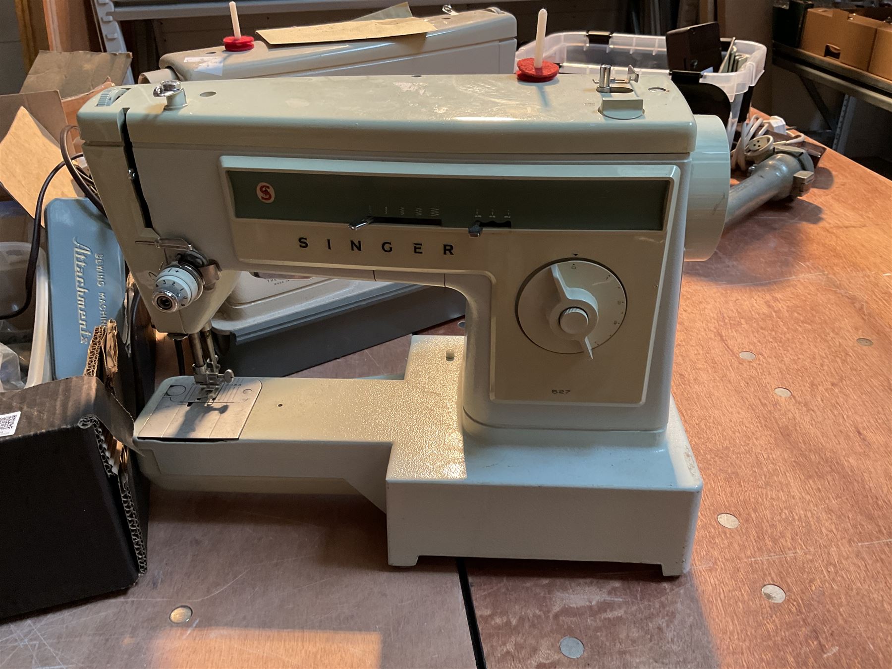 Two Singer sewing machines, model numbers 527 and 457, together with various Singer sewing machine parts, and a selection of sewing related accessories, to include threads, sewing needles, etc.