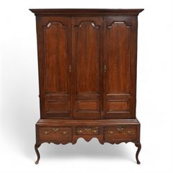 Georgian oak livery cupboard, projecting cornice over panelled front with mahogany bandings, enclosed by two doors, the base fitted with three drawers over shaped apron and cabriole supports 