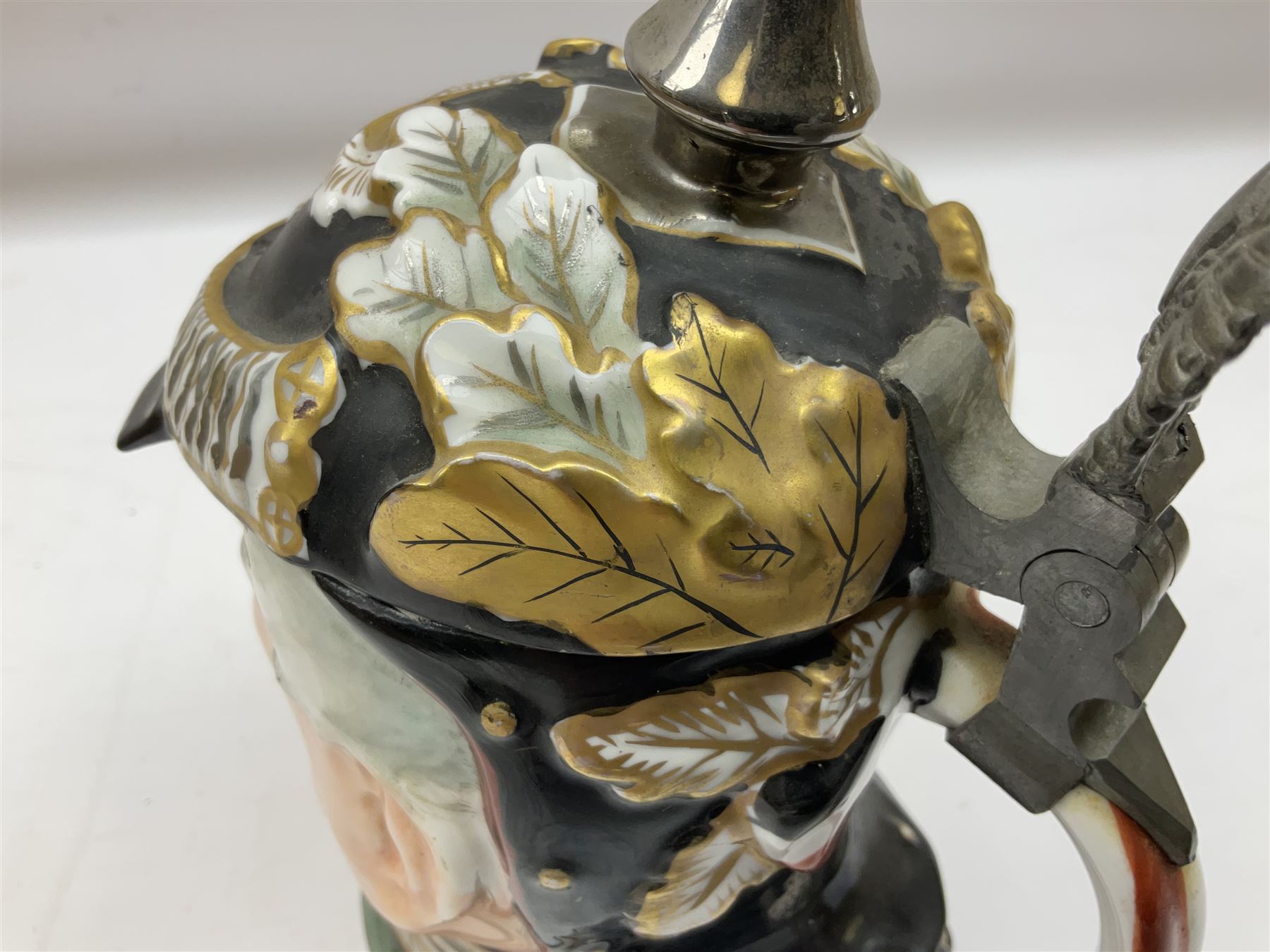 Otto Von Bismarck figural 0.5l stein, his black pickelhaube helmet with chrome spike serving as the lid, in green uniform and gilt detail throughout, pewter thumb hinge, with blue hash Musterschutz type mark, H18cm