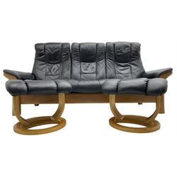 Stressless - 'Buckingham' three-seat settee upholstered in black leather; together with two associated footstools 