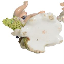 Pair of 19th century Stevenson and Hancock Derby figural chambersticks, each modelled as a seated cherub with arm around foliate encrusted sconce, marked beneath, H18cm