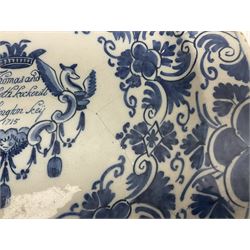 Early 18th century Delft marriage plate, of circular form with dished centre, the centre inscribed and dated 'Thomas and Elizabeth Kockerill Bridlington Key 1715' within a crowned C scroll cartouche, flanked by demi-griffins, above a putto head and tassels, within a wide foliate border, D34cm
