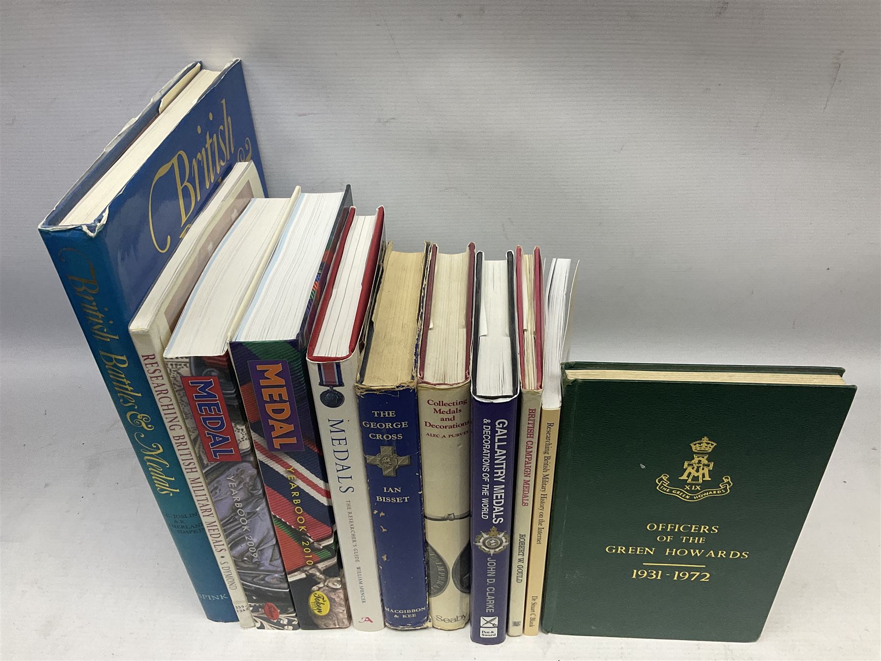 Eleven medal reference books including Ian Bisset: The George Cross; Spinks British Battles & Medals; William Spencer: Medals - The Researchers Guide; John D. Clarke: Gallantry Medals & Decorations of the World; Officers of The Green Howards 1931-1972; and six others (11)