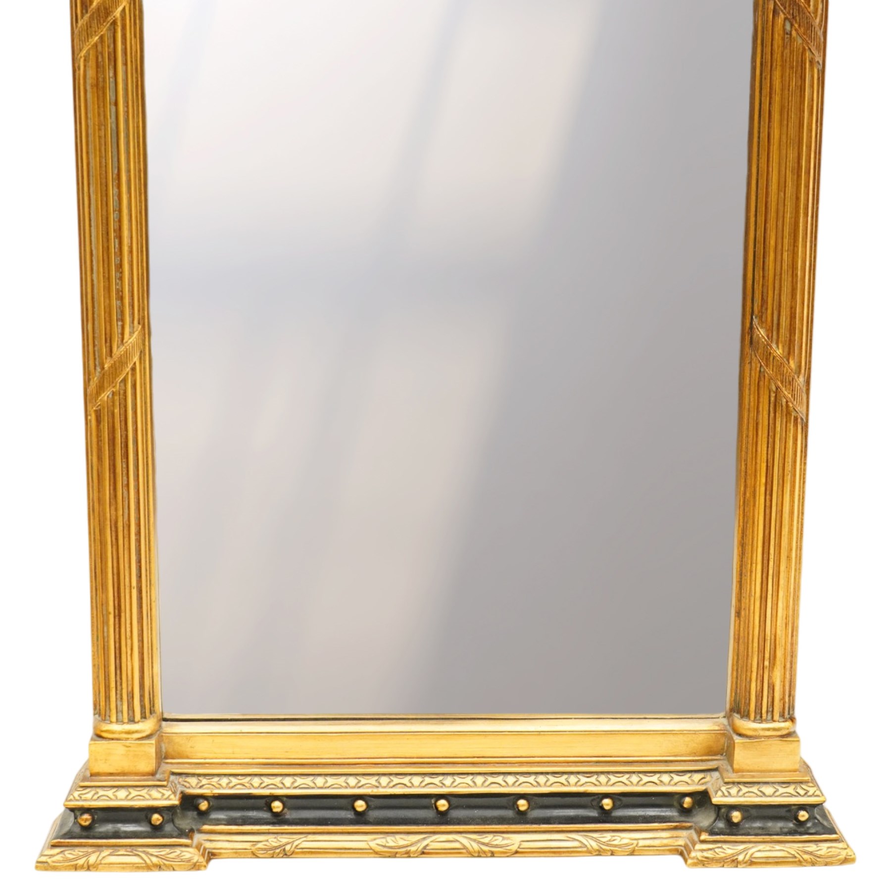 Tall Gothic Revival ebonised and gilt pier mirror, the projecting cornice with foliate ornament and applied spherical mounts, over a Gothic tracery frieze with trefoil motifs, the bevelled rectangular plate flanked by fluted Neoclassical columns with acanthus capitals, on a stepped ebonised and gilt plinth base with globular mounts