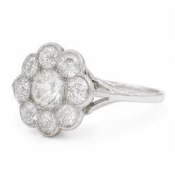 Early 20th century platinum diamond daisy flower head cluster ring, principal round cut diamond of approx 0.65 carat, surrounded by eight milgrain set old cut diamonds, within a pierced scroll design gallery, total diamond weight approx 2.15 carat