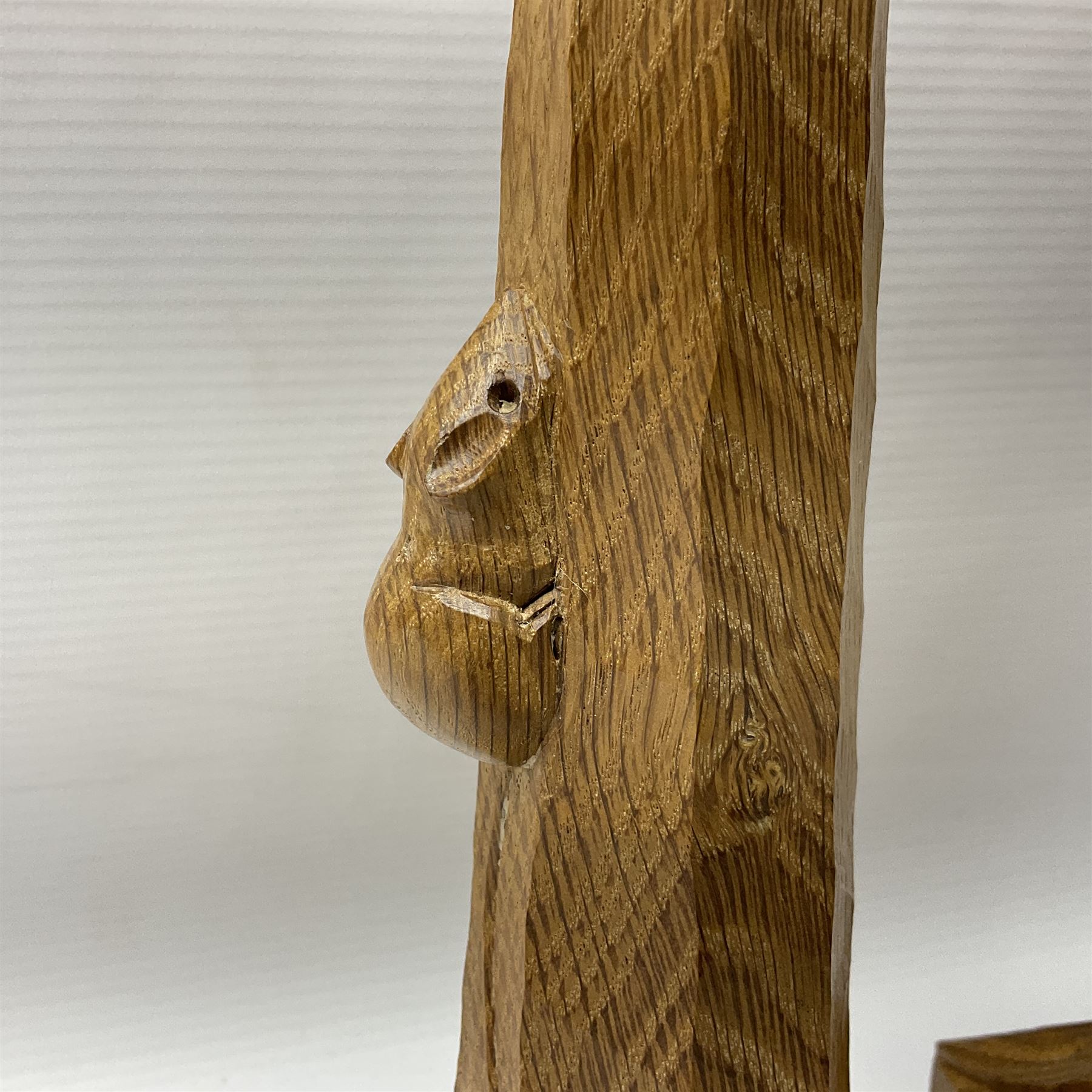 Mouseman - pair of tooled oak candlesticks, wrought iron sconce with drip tray over tapered octagonal column carved with mouse signature, terminating to stylised leaf carved square base, by the workshop of Robert Thompson, Kilburn
